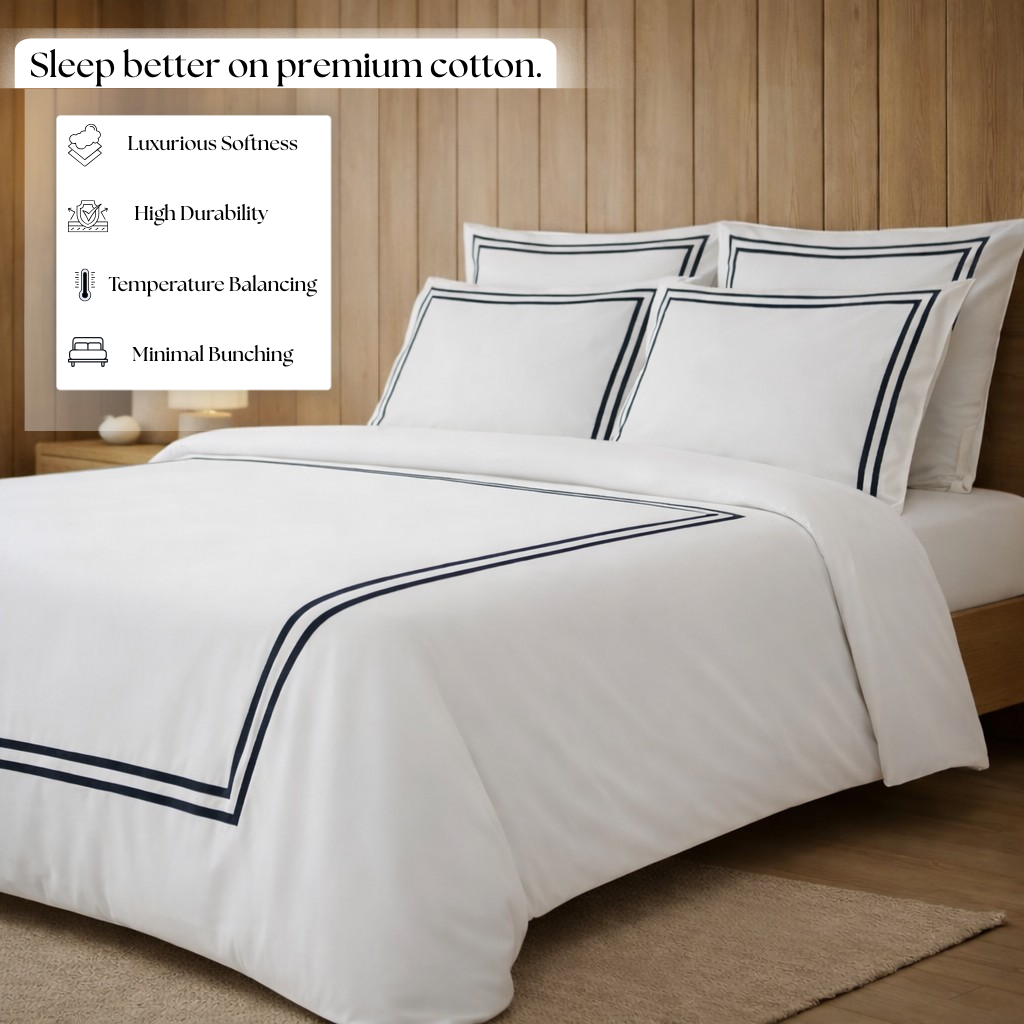 White bedding set with black trims on a bed in a bedroom setting, featuring text about premium cotton benefits.