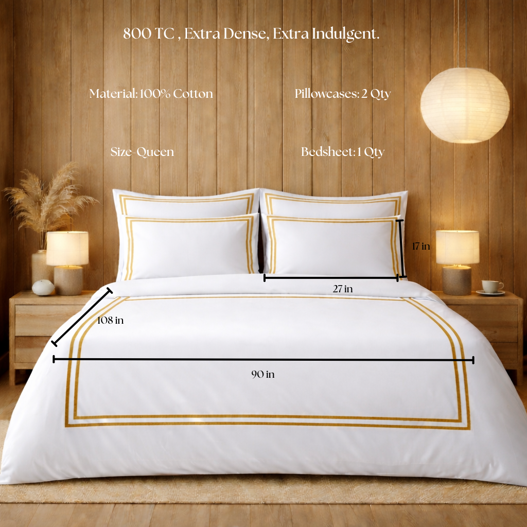 White bedding set with gold trim on a bed in a bedroom setting, showing dimensions and material details.