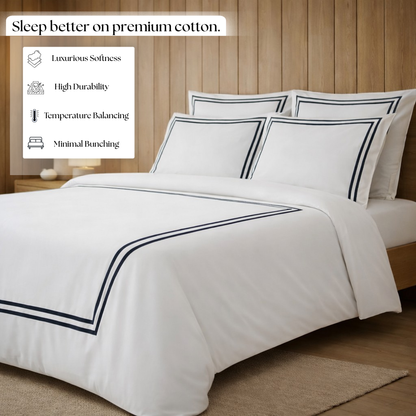 White bedding set with black trims on a bed in a bedroom setting, featuring text about premium cotton benefits.