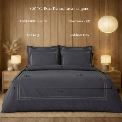Gray bedding set with dimensions on a wooden bed frame, against a wooden wall.
