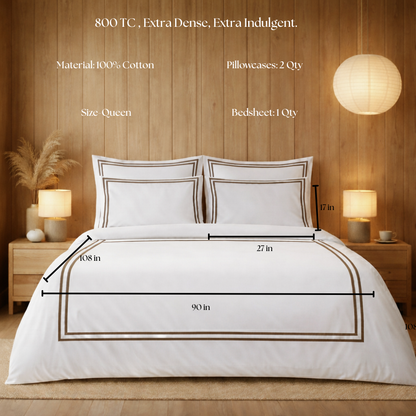 White bedding set with measurements on a bed in a bedroom setting.