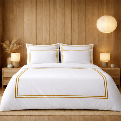 White bedspread with gold trim in a bedroom setting