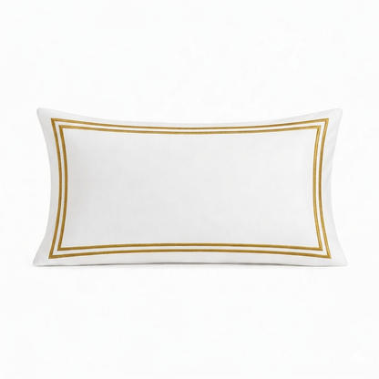 White pillow with gold border on a white background