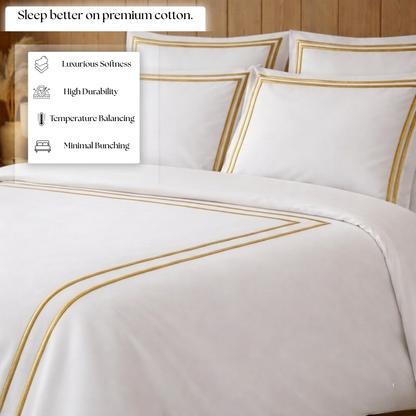 White bedding set with gold accents on a bed, featuring text about premium cotton benefits.